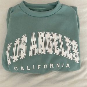 Green Shein crewneck. Says “LOS ANGELES CALIFORNIA”. Yellow sleves. Small.